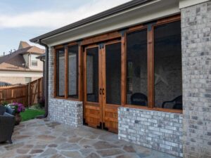backyard sunroom with white brick and wooden framing with screens